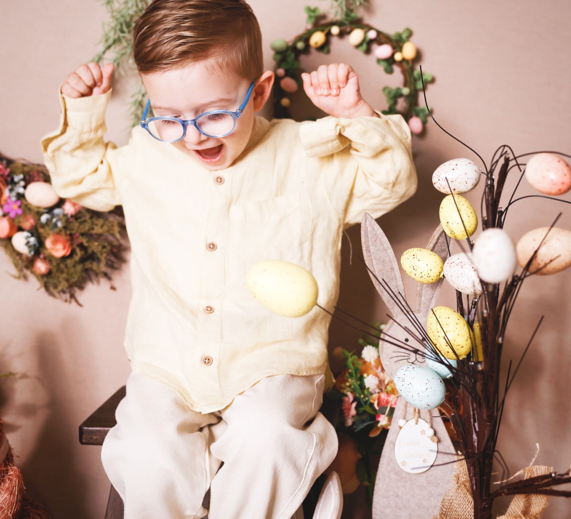 Boy cheering with both arms raised in a spring set