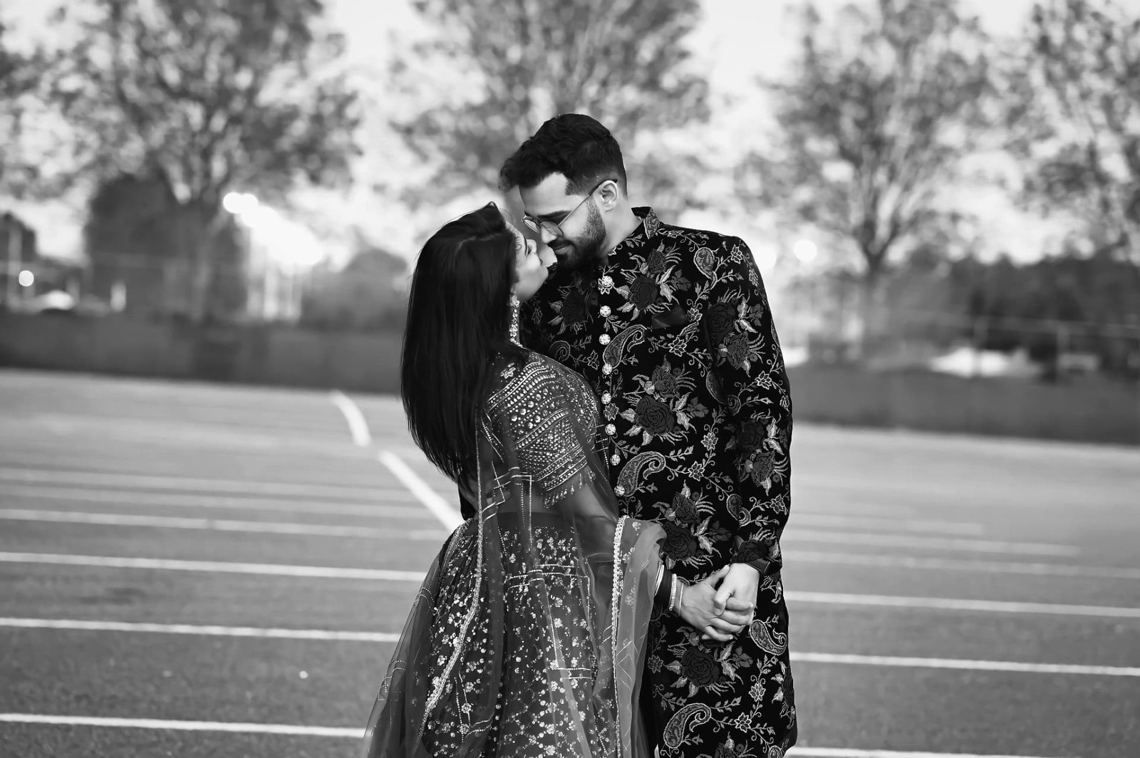 Black and white photo of a couple in traditional dress leaning in close