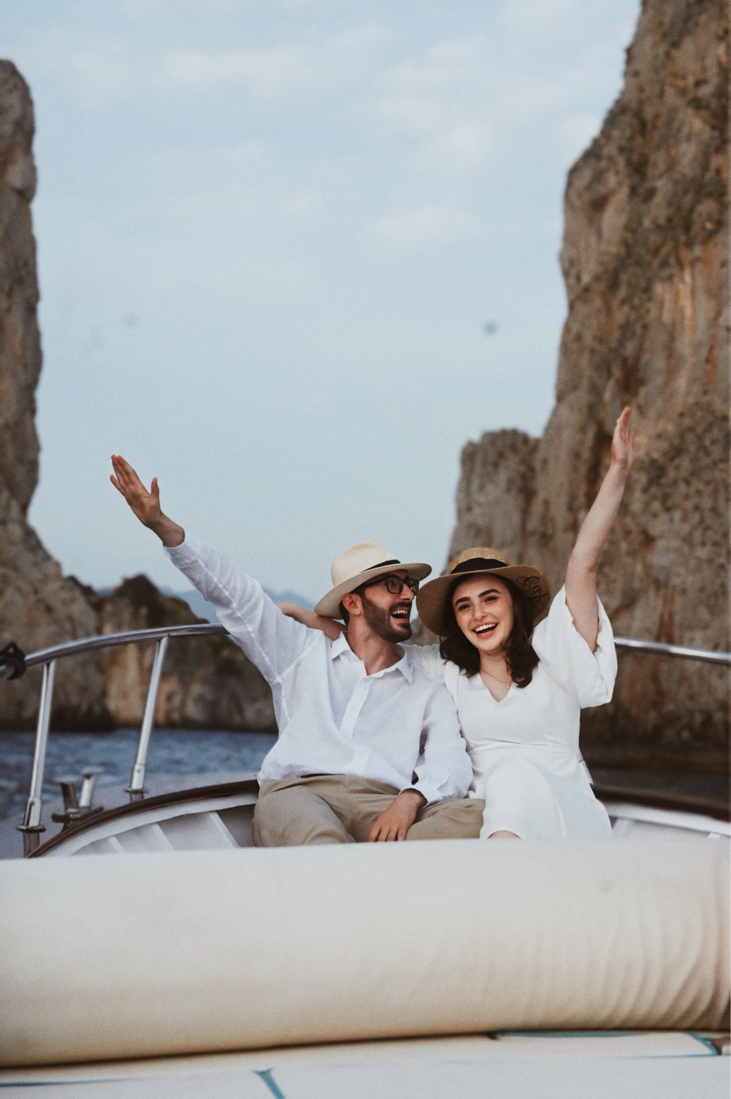 Couple cheering with arms raised on a boat