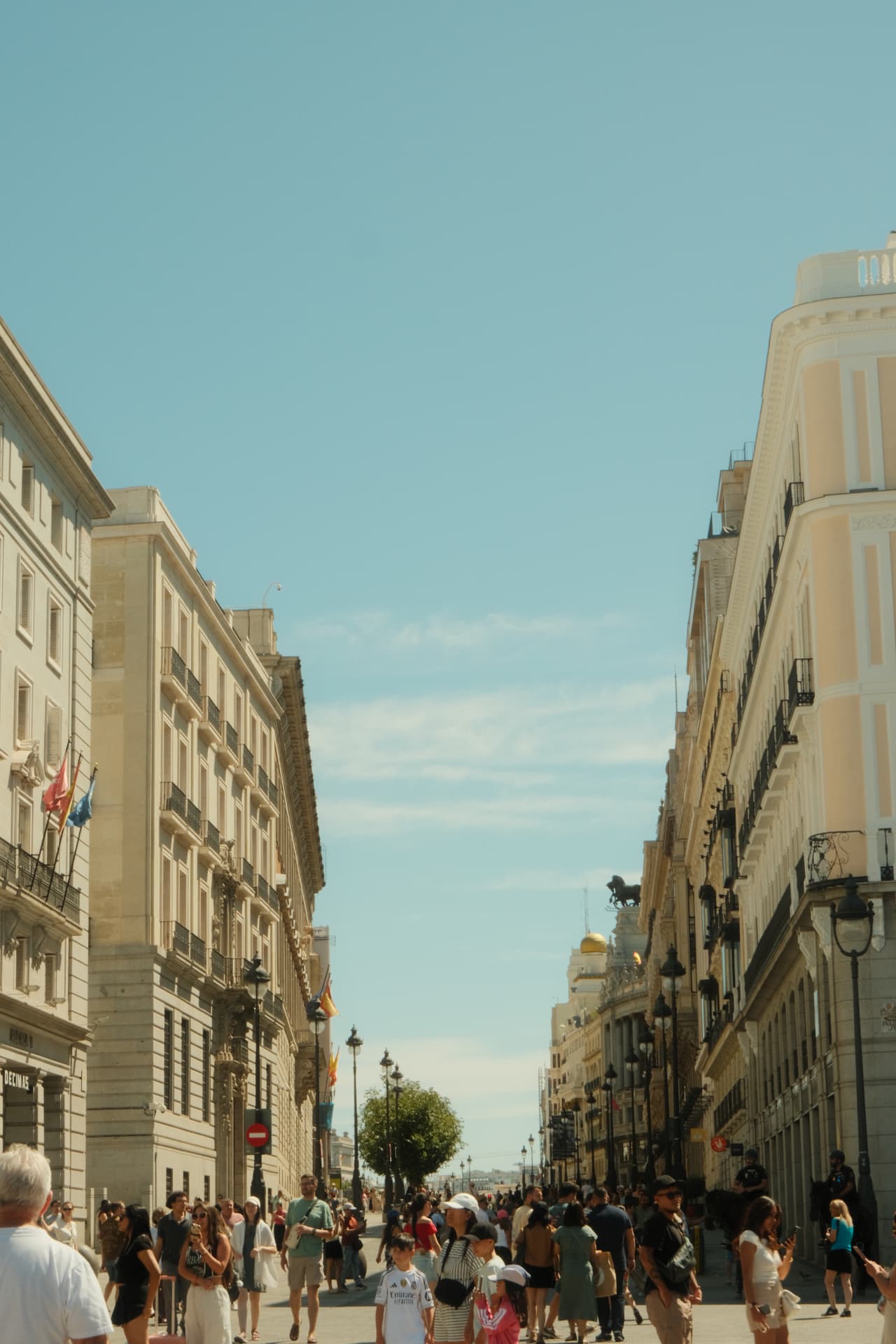 Busy Madrid street looking towards Gran Vía on a clear summer day