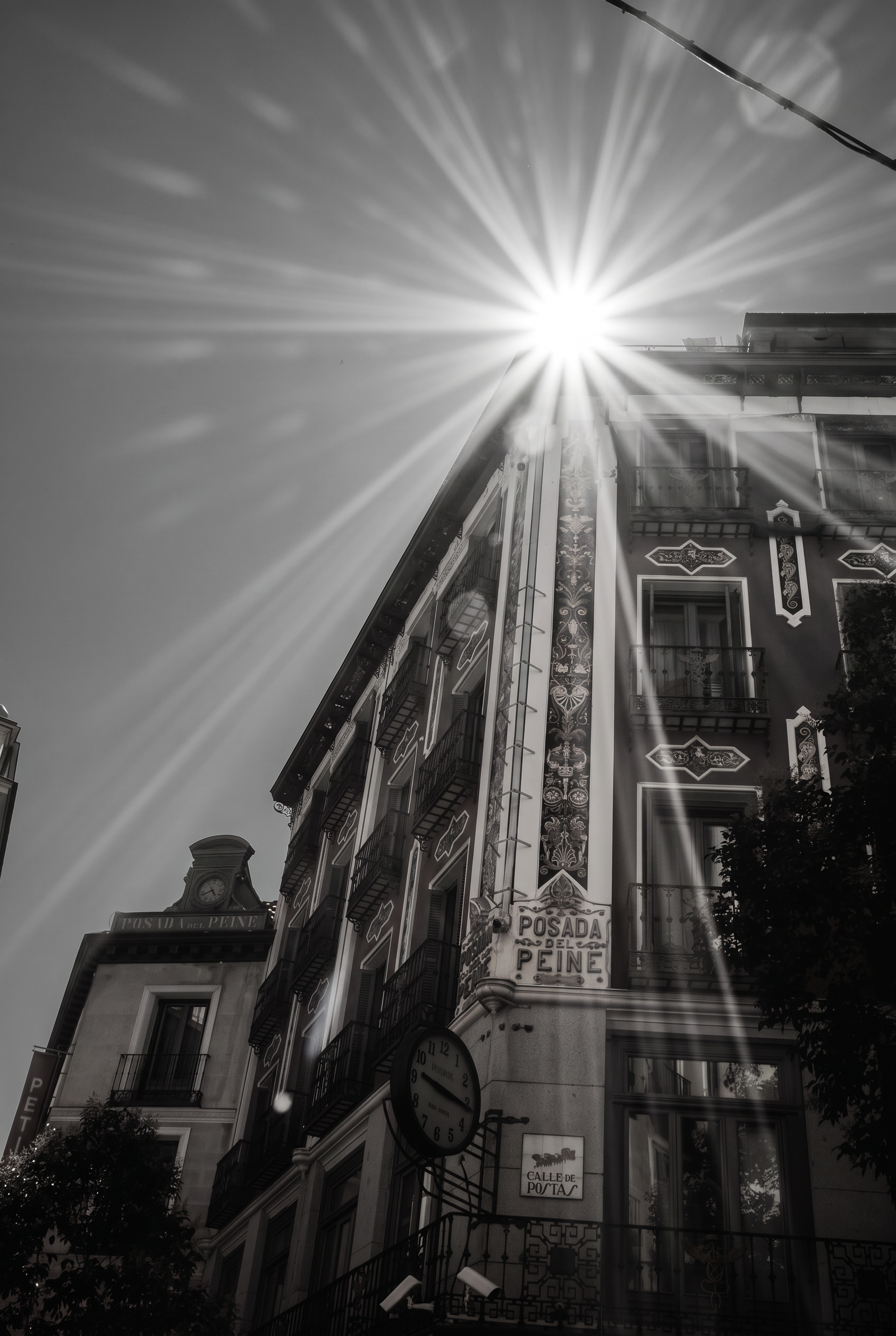 Sun bursting over the tiled facade of a historic Madrid building