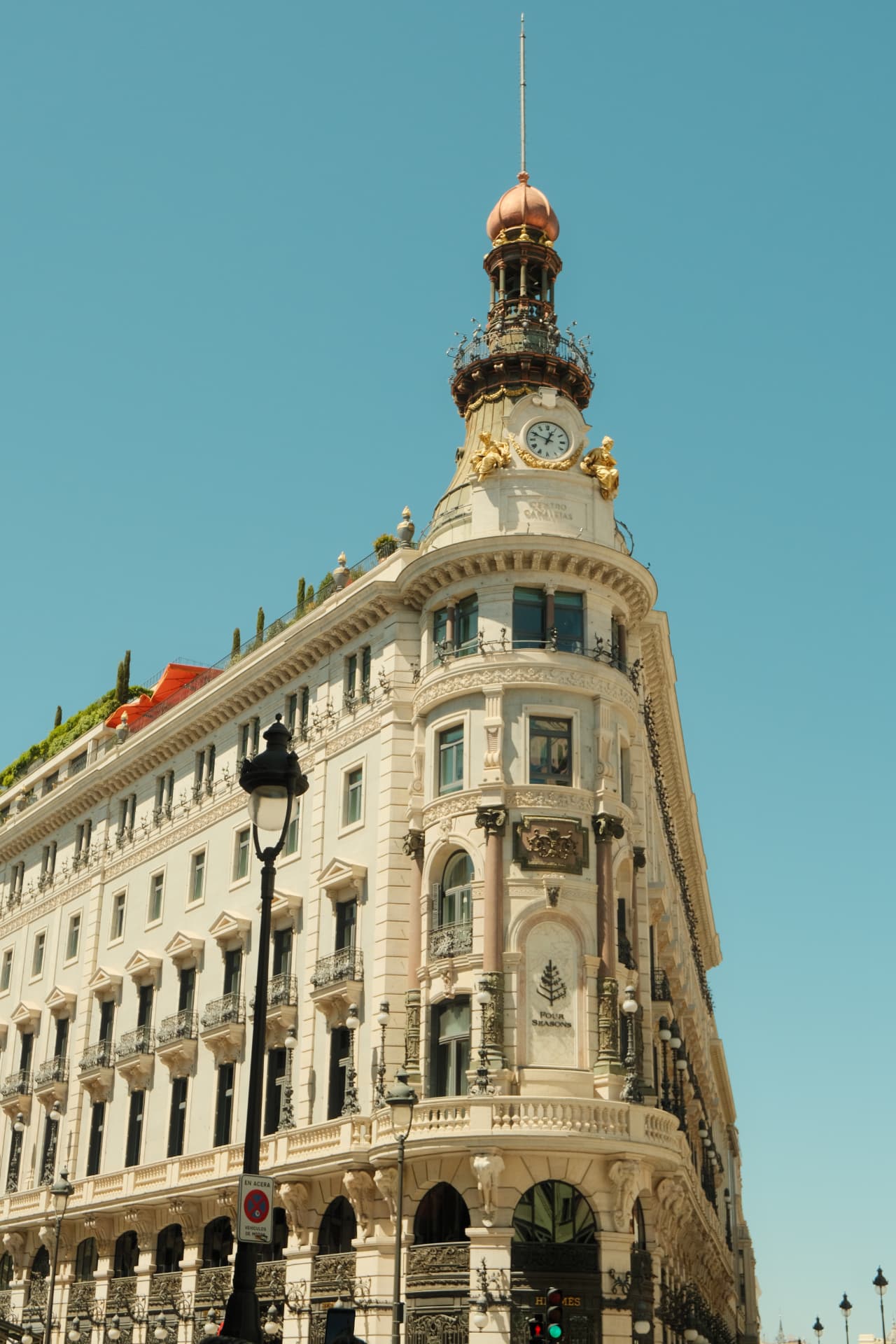 Ornate corner tower of a grand Madrid building against a blue sky